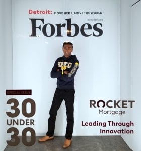 Ismail poses in a booth that makes him look like he is on the cover of Forbes Magazine.