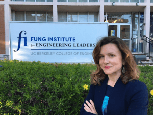 Lida standing in front of Shires Hall and the Fung Institute sign with her arms crossed